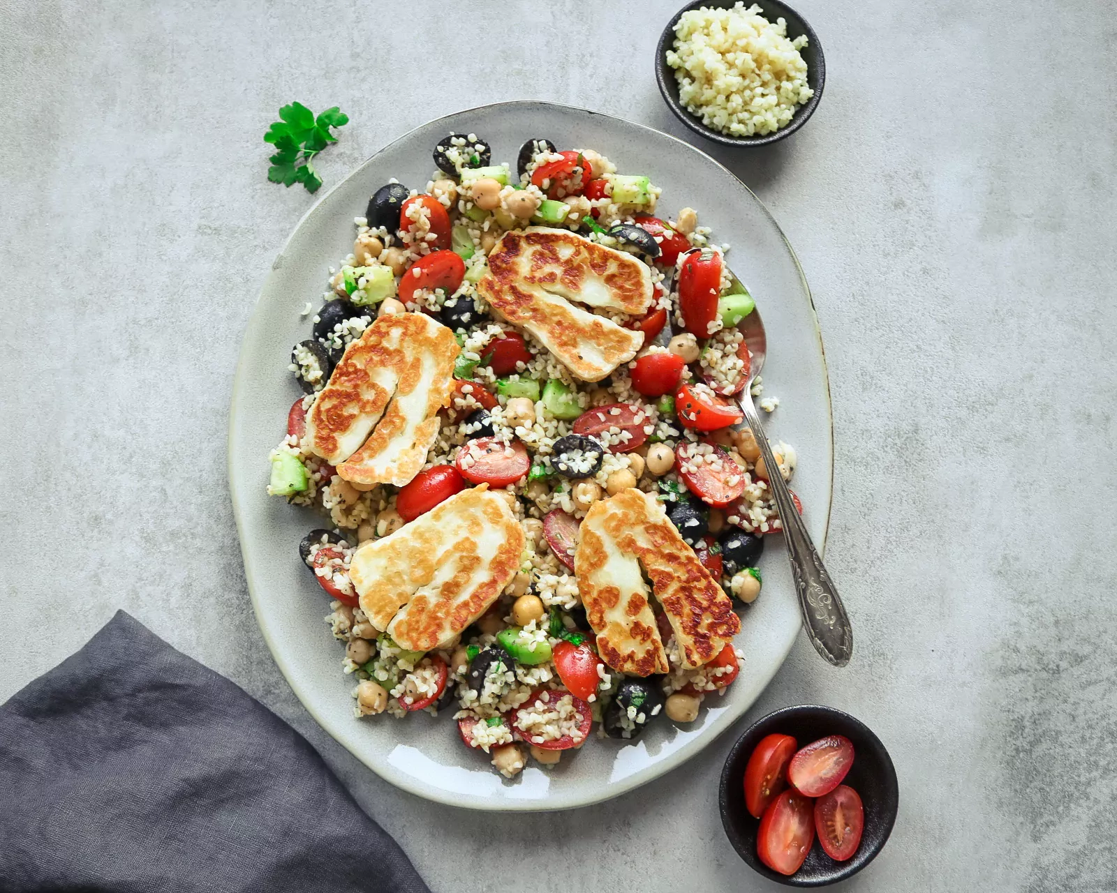 Жареный халуми с крупой булгур, помидорами черри и оливками